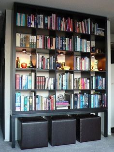 a bookshelf filled with lots of books and bins