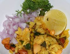 a white plate topped with rice and beans next to a lemon wedge on top of onions