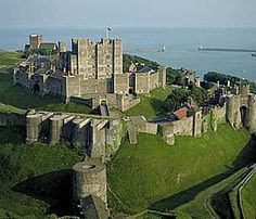 an aerial view of a castle with water in the background