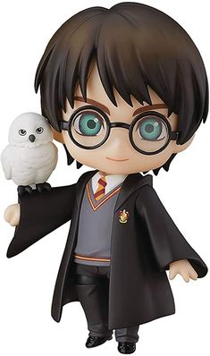 a harry potter figurine with an owl on his arm, holding it in one hand