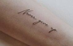 a woman's arm with the word never give up written in cursive writing