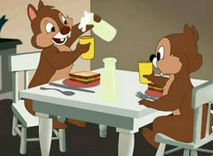 two chipmuns sitting at a table eating food