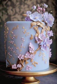 a blue and gold cake with flowers on it