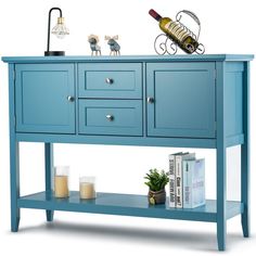 a blue sideboard with two drawers and a wine bottle on it's top