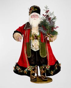 a santa clause figurine holding a christmas tree in his hand and standing on a pedestal