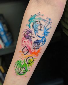 a colorful tattoo on the arm of a person's left arm, with different colored shapes