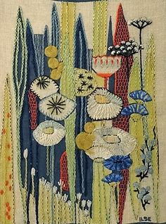 an embroidered wall hanging with flowers and leaves on it's side, in blue and yellow