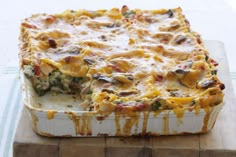 a casserole dish with broccoli, cheese and other toppings on a cutting board