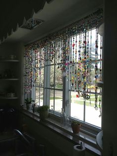 a kitchen window covered in lots of colorful beads