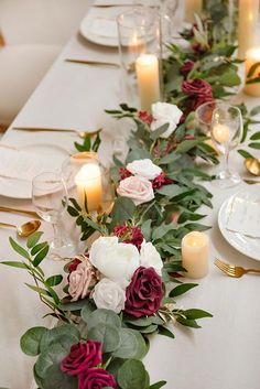 a long table with flowers and candles on it