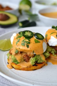 two loaded burgers on a white plate with avocado and sour cream sauce