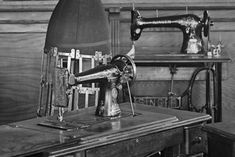 an old fashioned sewing machine sitting on top of a wooden table next to a chair