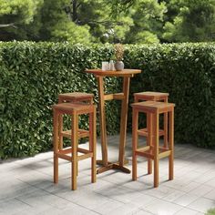 three wooden stools sitting next to each other in front of a hedge