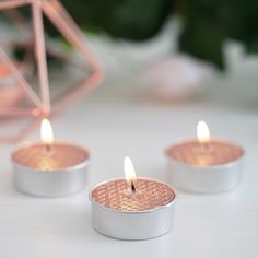 three lit candles sitting on top of a table