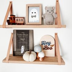 two wooden shelves with pictures and toys on them, one shelf has a teddy bear