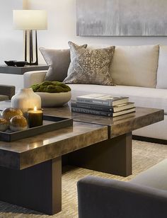 a living room filled with furniture and a coffee table in front of a white couch