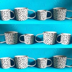 four rows of white polka dot coffee cups lined up against a blue wall