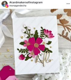 a card with pink flowers and green leaves on it