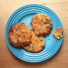 three crab cakes are on a blue plate