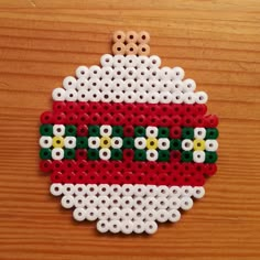 a christmas ornament made out of perler beads on a wooden table top