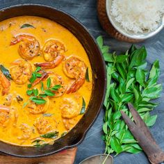 a skillet filled with shrimp and rice on top of a table