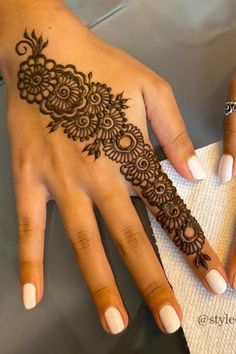 two hands with henna tattoos on them