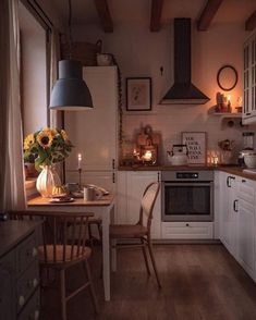 a kitchen filled with lots of furniture and decor on top of wooden floored floors