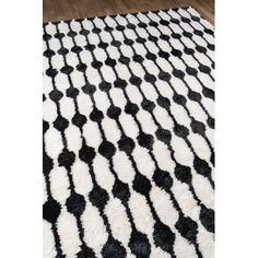 a black and white rug on top of a wooden floor