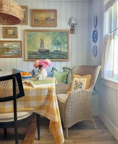 a dining room with chairs, table and pictures on the wall