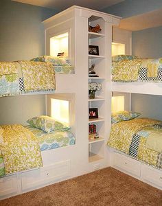 there are three bunk beds with lights on the top and bottom shelves in this room