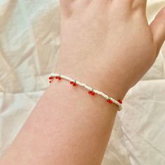 This dainty cherry bracelet is minimal yet still makes a good simple statement piece. The white seed beads are pearly looking and contrast the red and green of the mini cherries perfectly. My jewelry is made to be size inclusive.  The smallest length of the bracelet is 7.25 inches and can be adjusted up to 8.75 inches, however, if you need it to be 1+ inches smaller or 2+ inches larger than 7.25 inches let me know in the customization section of this listing (or message me) and I will custom mak Trendy Red Beaded Bracelets With Tiny Beads, Dainty Red Beaded Bracelets With Tiny Beads, Dainty Red Beaded Bracelets, Minimalist Red Beaded Bracelet With Tiny Beads, Red Beaded Dainty Bracelets, Minimalist Red Beaded Bracelets For Everyday, Red Minimalist Beaded Bracelets For Everyday, Dainty Red Beaded Bracelets For Everyday, Red Minimalist Bracelet For Everyday