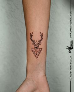 a small deer head tattoo on the wrist