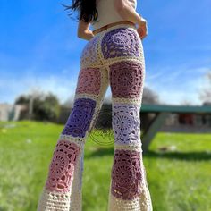 a woman is wearing crocheted pants in the grass