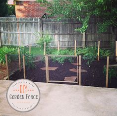 the garden fence is made out of wood and metal wire, with plants growing in it