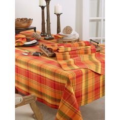 the table is covered with plaid cloths and place settings for two people to sit at