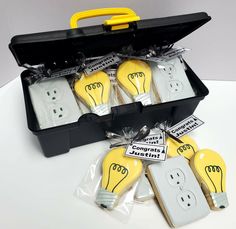 a suitcase filled with lots of yellow lightbulbs next to some electrical plugs