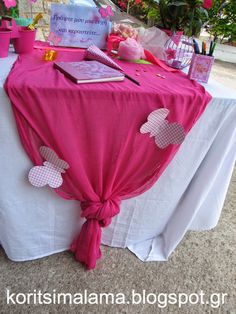 the table is covered with pink and white decorations