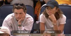 two people sitting next to each other at a tennis match