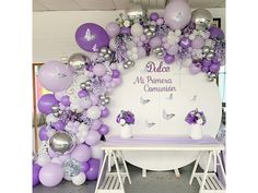 purple and silver balloons decorate the backdrop for an event