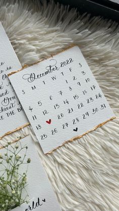 two calendar cards with flowers on them sitting on a furnishing area next to each other