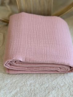 a pink blanket folded on top of a bed