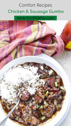 a white bowl filled with stew and rice next to a bottle of hot dog sauce