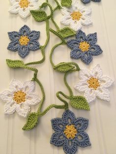 crocheted flowers with green stems and white petals