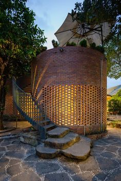 an outdoor area with steps, umbrella and brick structure in the background at night time