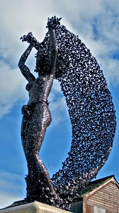 a statue is shown in the shape of a woman's body with birds all over it