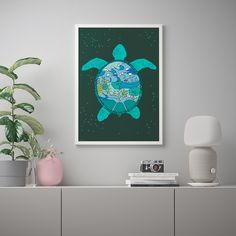 a green turtle is on the wall next to a white cabinet and potted plant