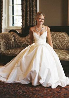 a woman in a wedding dress sitting on a couch