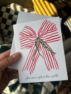 someone holding up a card with a bow on it