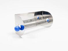 a metal contraption with blue balls on the top and two holes in the middle