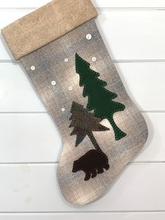 a christmas stocking hanging on the wall with bears and trees painted on it's side